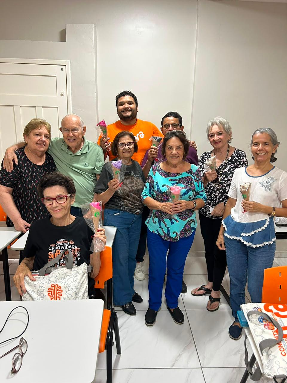 Alunas segurando flores em comemoração do Dia das Mulheres no SUPERA